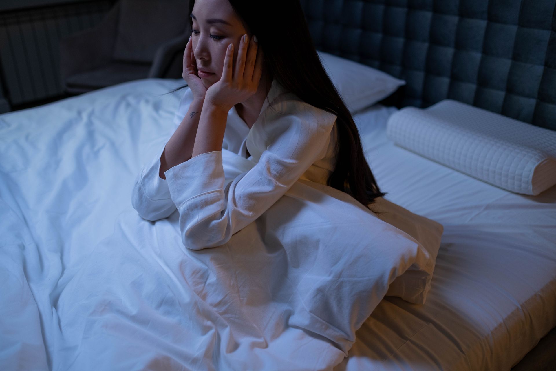 Vrouw zit midden in de nacht wakker rechtop in bed